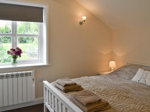 a bedroom with a bed and a window at The Willows in Toynton All Saints