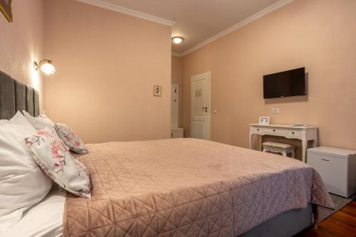 a bedroom with a bed and a tv on the wall at Vila Missy in Deva