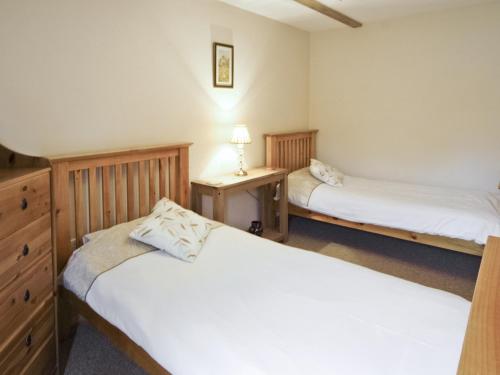 HalstonにあるShippon Cottage - E4299aのベッドルーム1室(ベッド2台、ランプ付きドレッサー付)