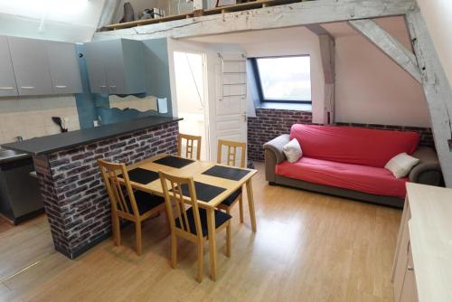 Il comprend une cuisine et un salon avec un canapé rouge. dans l'établissement Le Duplex Central - Hyper Centre - Arras, à Arras