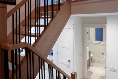 a wooden staircase in a home with white walls at Stunning TreeTop Views at HighParkHomes dot ca in Toronto