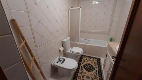 y baño con aseo, lavabo y bañera. en Casinha do Rui, en Sines