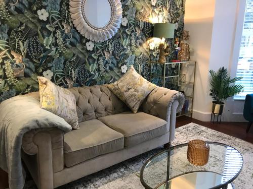 a living room with a couch and a table at The Cheltenham, stylish 1-bed Victorian apartment in Harrogate