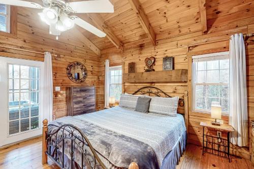 a bedroom with a bed in a room with wooden walls at Victorian Secret in Sautee Nacoochee