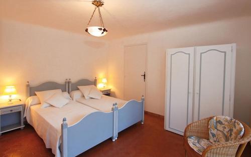 a bedroom with a blue bed and a chair at La bayorre in Hyères