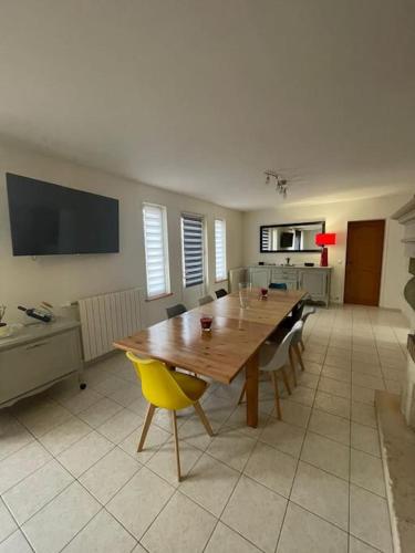 une salle à manger avec une table et des chaises en bois dans l'établissement Maison bord de mer Chez JuJu, à Grandcamp-Maisy