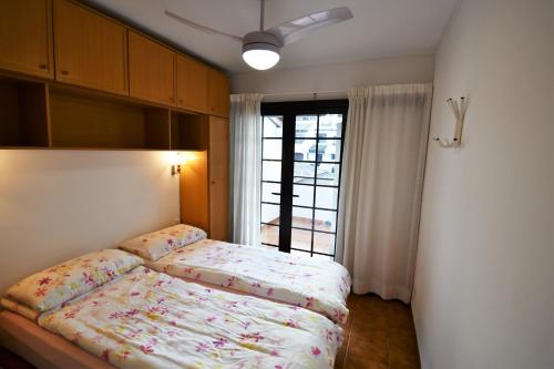 een kleine slaapkamer met een bed en een raam bij Appartement Sant Antoni in Sant Antoni de Calonge