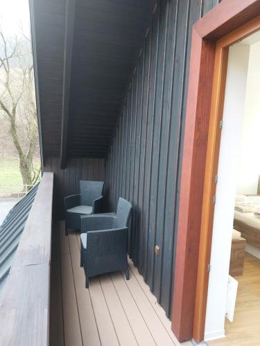 a room with two chairs and a table on a deck at Polanský Dvůr in Velké Karlovice