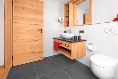 a bathroom with a toilet and a sink at Chalet-Ferienwohnung Schlossblick, 51 qm, Wellness/Fitness/Sauna – Bergrödelhof in Feilitzsch