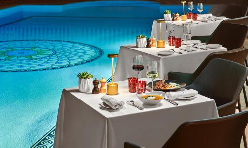 坎城的住宿－雄偉戛納巴里耶爾酒店，一张桌子,上面有白色的桌子,上面有食物和葡萄酒