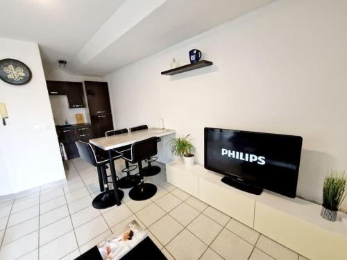 a living room with a tv and a table in a room at Agréable appartement T2 Centre ville in Valence