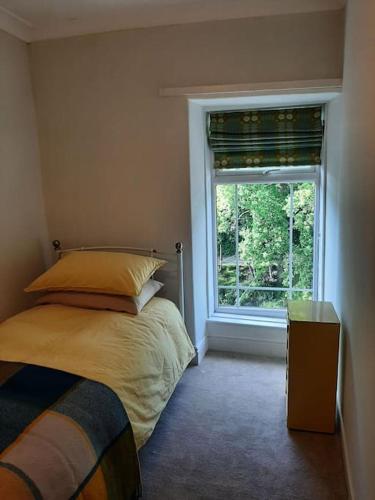 a bedroom with a bed and a window at Selah Teifi spectacular river view with games room in Llandysul