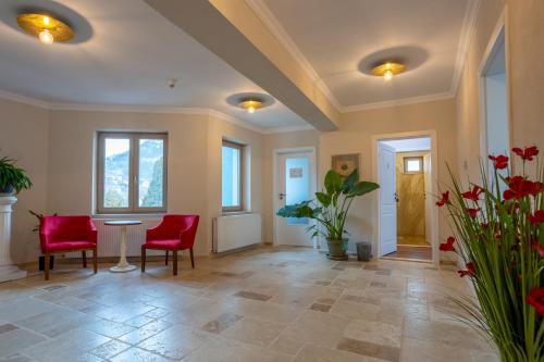 a large room with red chairs and a table at Vila Missy in Deva