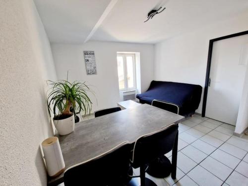 a living room with a table and chairs and a couch at Agréable appartement T2 Centre ville in Valence