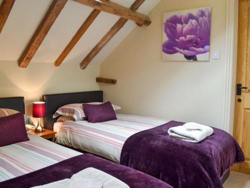 a bedroom with two beds and a painting on the wall at The Granary in Aldbrough