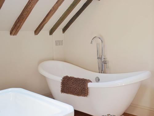 a bathroom with a white bath tub next to a toilet at The Granary in Aldbrough