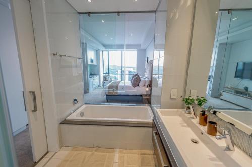 een grote badkamer met een bad en een wastafel bij Sandton Skye Serviced Apartments in Johannesburg