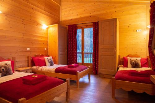 a bedroom with two beds in a log cabin at Chalet Rosko by Chalet Chardons in Tignes