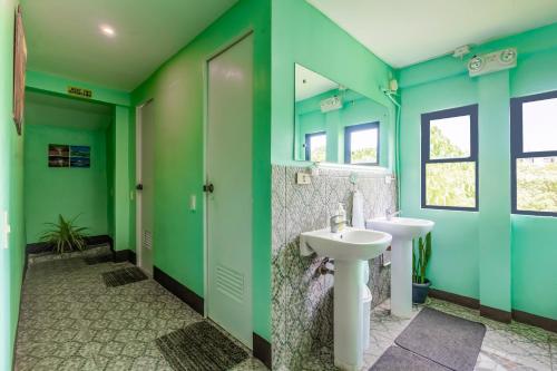 baño con paredes verdes y lavabo en White Shamrock Beach Hotel en Boracay