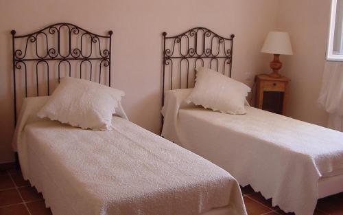 Cette chambre comprend 2 lits avec des draps et des oreillers blancs. dans l'établissement Le mas des oliviers, à Fox-Amphoux