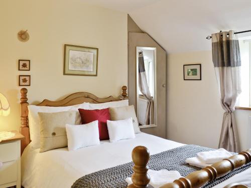 a bedroom with a large white bed with red pillows at The Old Mill in Bampton