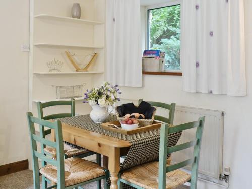 a dining room table with chairs and a vase of fruit at The Old Mill in Bampton