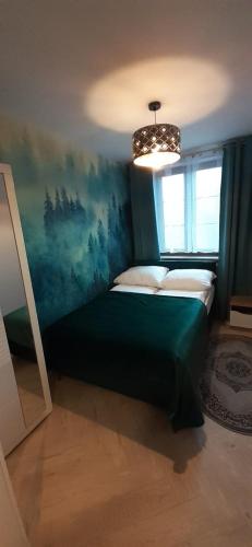Un dormitorio con una cama verde y una ventana en Jagoda 11, en Karpacz