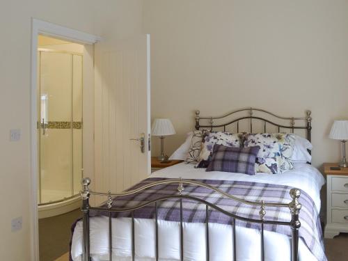 a bedroom with a bed and a walk in shower at Betley Court Farm 1 in Betley