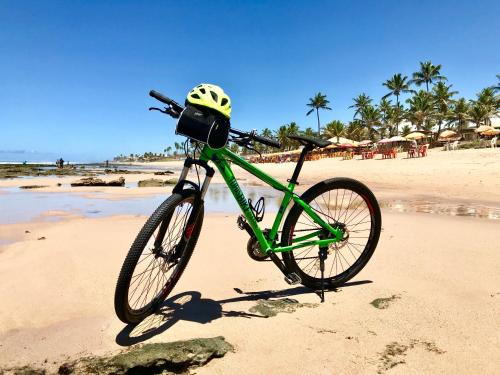 Una bicicleta estacionada en una playa con un casco. en TURISHOUSE SUITES, en Salvador