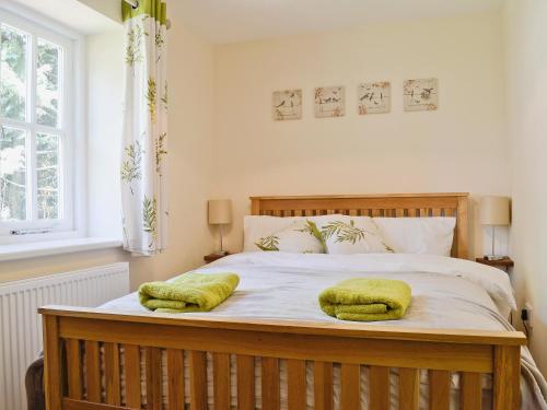 a bedroom with a bed with two pillows on it at Bowles Cottage in Lechlade