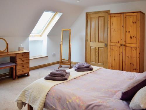 1 dormitorio con 1 cama con toallas en The Old Coach House en St Austell