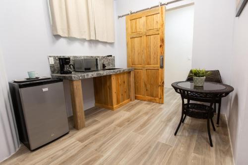 a small kitchen with a table and a microwave at Sea Eye Hotel - Laguna Building in Utila