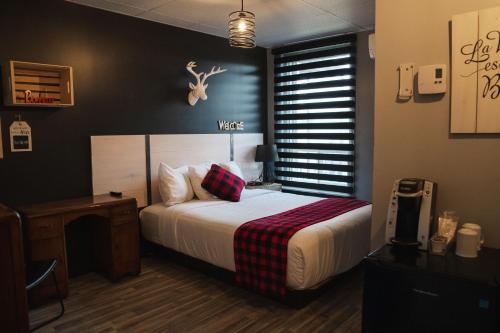 a bedroom with a bed with a deer head on the wall at Auberge Beausejour in Amqui