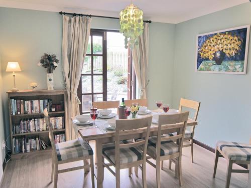 a dining room with a table and chairs and a window at Pebble Cottage - Hw7447 in Broad Haven