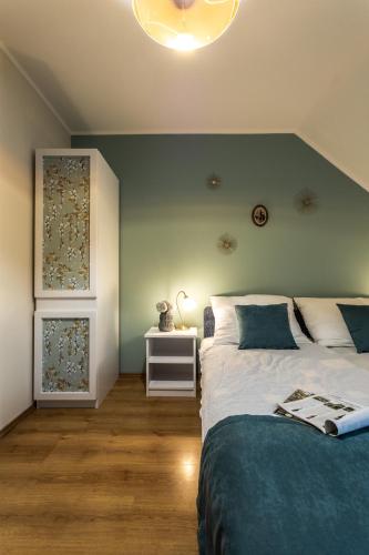 a bedroom with a bed with a blue wall at Kikerics vendégház in Villány
