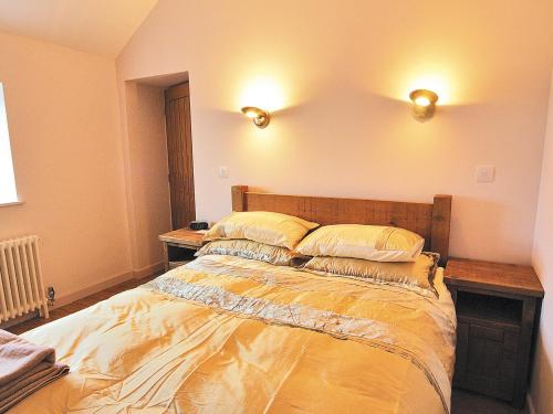a bed in a room with two lights on the wall at Seion - Hw7575 in Llanddeiniolen