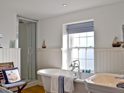 a bathroom with a bath tub and a sink at Tides in Cromarty