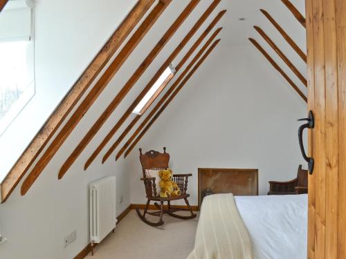 a bedroom with a bed and a chair in a room at Tides in Cromarty