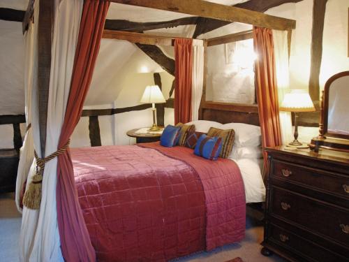 a bedroom with a canopy bed and a dresser at Hathaway Hamlet in Stratford-upon-Avon