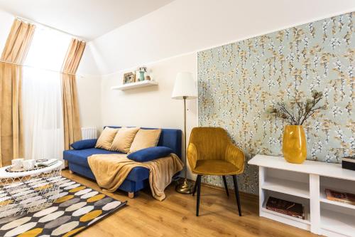 a living room with a blue couch and a chair at Kikerics vendégház in Villány