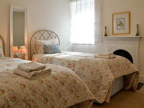 1 dormitorio con 2 camas y chimenea en Smithy House en Betws-y-coed
