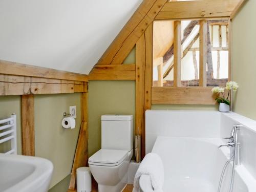 a bathroom with a white toilet and a sink at The Barn Reborn - Nrp in Winchcombe