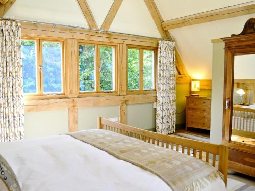a bedroom with a bed and a large window at The Barn Reborn - Nrp in Winchcombe