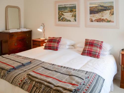 a bedroom with two beds with pillows and a mirror at The Cottage in Rispond