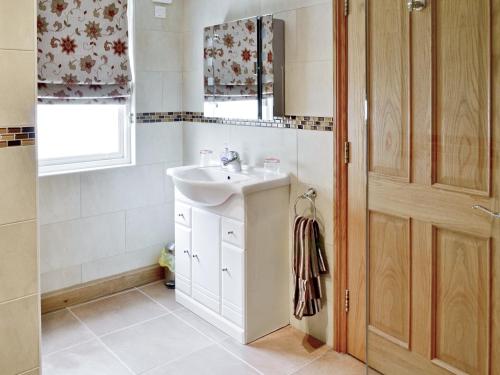 baño con lavabo y ventana en Low Tide, en Beadnell