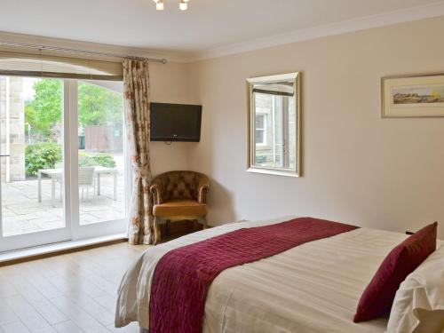 1 dormitorio con 1 cama y puerta corredera de cristal en Low Tide, en Beadnell