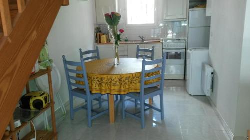 une cuisine avec une table, des chaises et un vase de fleurs dans l'établissement Les restanques de provence, à Bandol