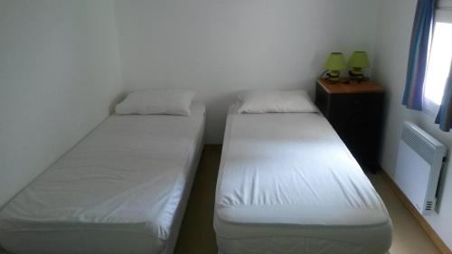 deux lits jumeaux dans une chambre avec fenêtre dans l'établissement Les restanques de provence, à Bandol