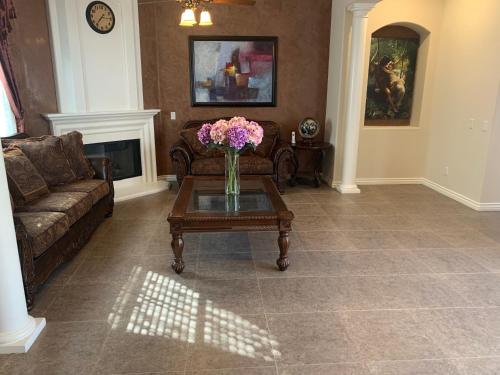 a living room with a vase of flowers on a coffee table at HighEnd Rooms in Mansion in Riverside