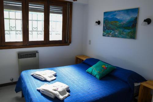 Un dormitorio con una cama azul con toallas. en Casa Limón, en Chascomús